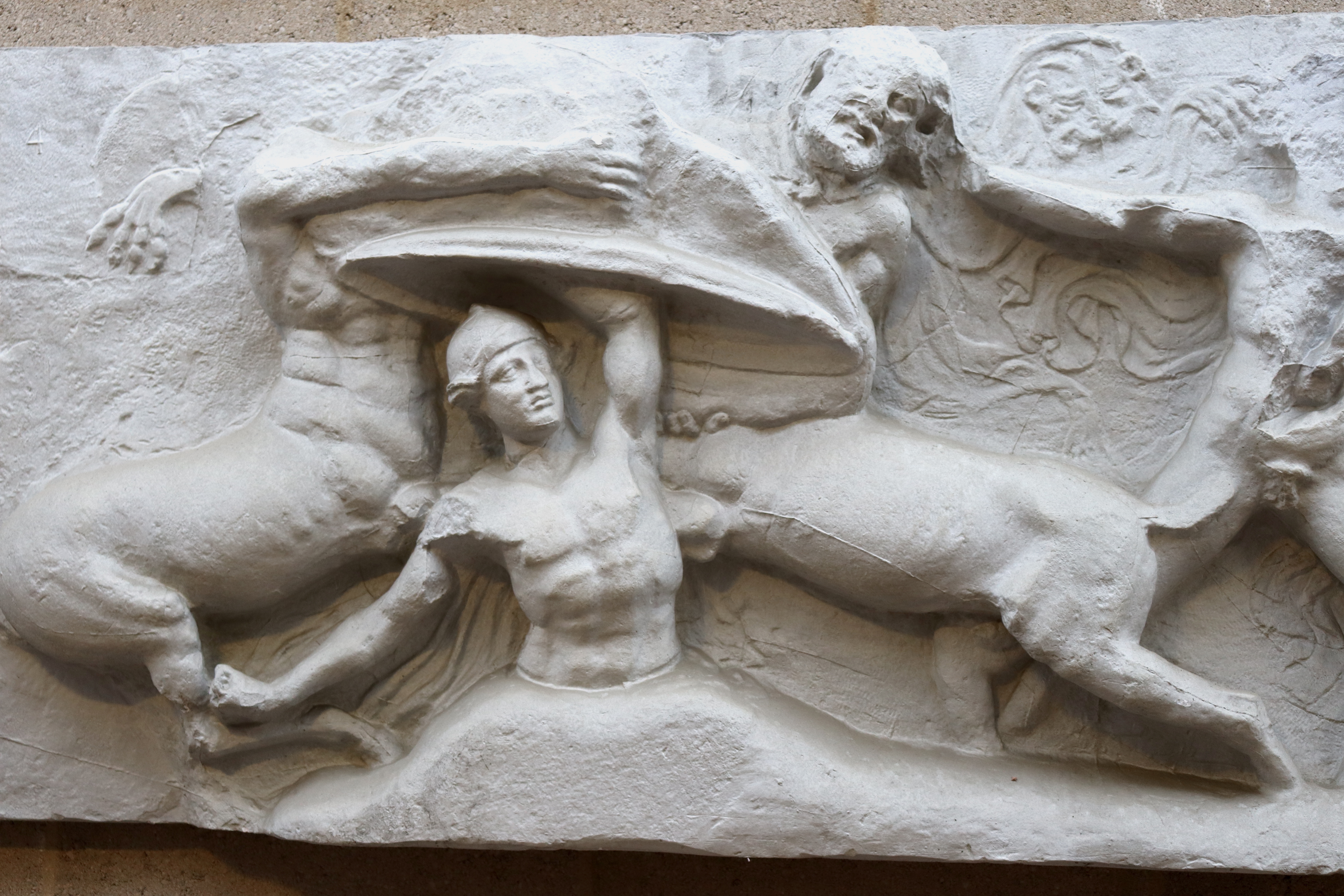 scene from Bassai frieze with Caineus being beaten into ground by centaurs