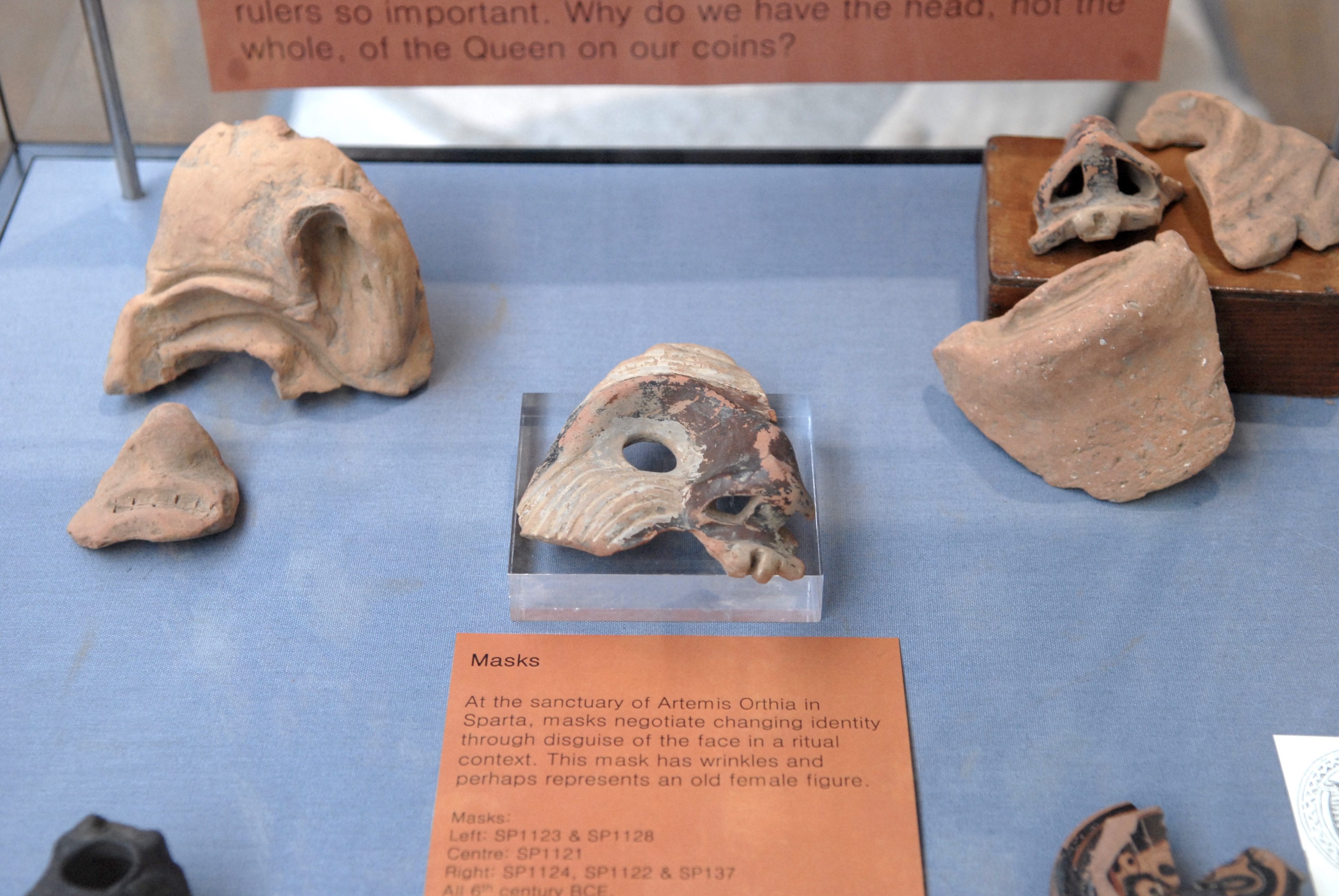 display cabinet with broken masks and pottery sherds