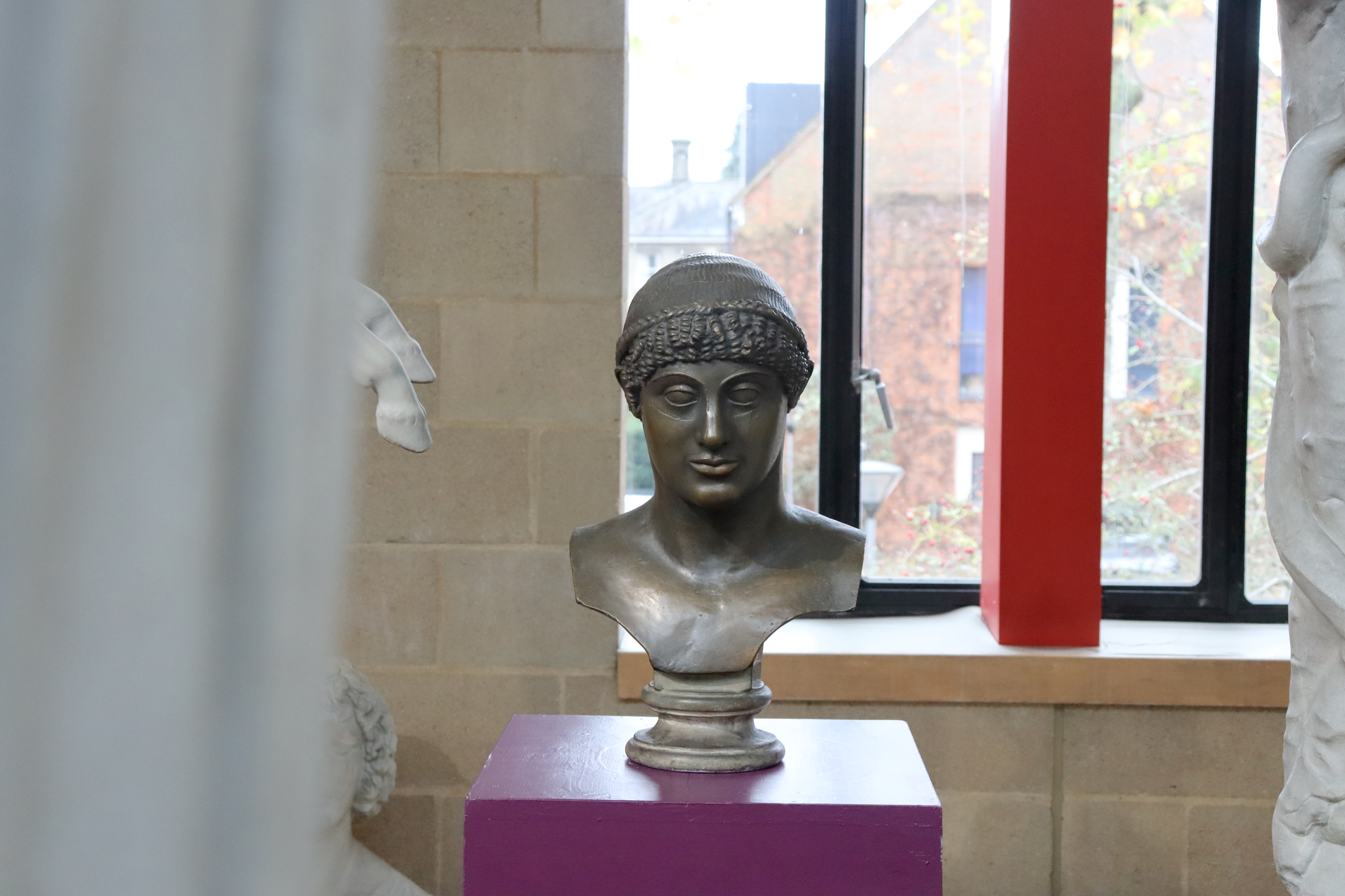 plaster cast of bronze male head, with spiral curls falling on forehead