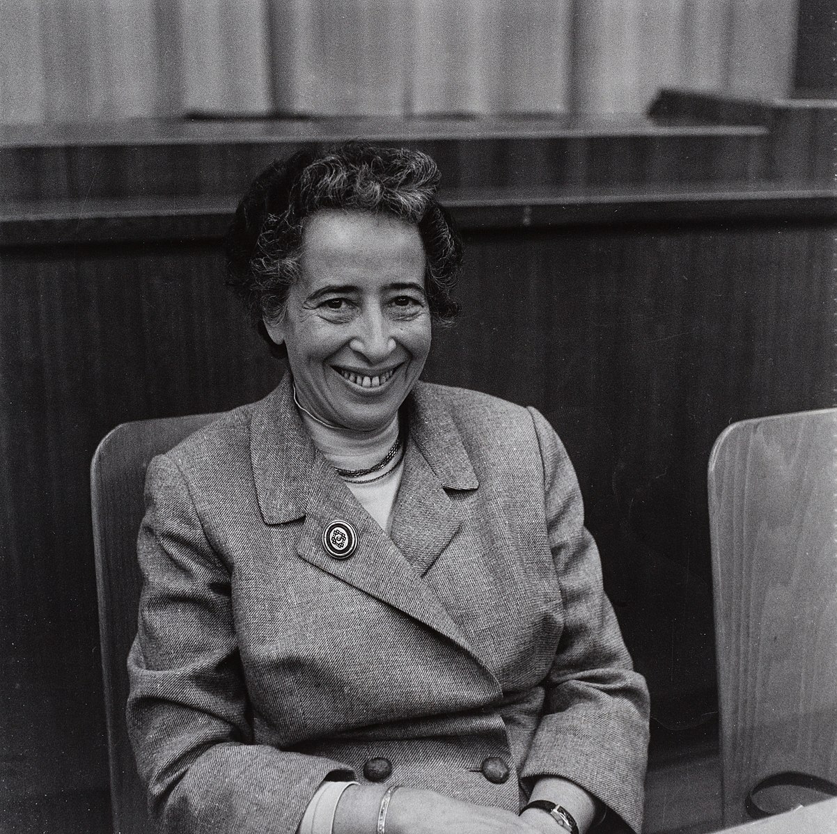 Black and white image of Hannah Arendt, seated and wearing a suit