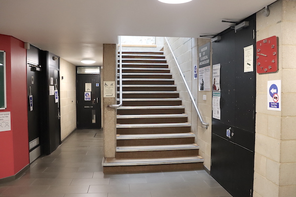 view of staircase with handrails, photographed from downstairs looking up