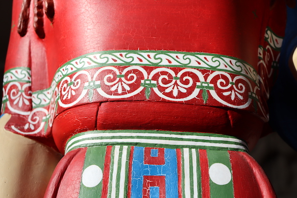 detail of painted Peplos Kore's red dress, with green, white and blue detailing