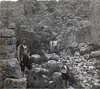 black and white photo of three local Turkish men and a little boy standing in ruins