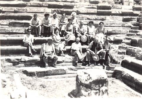 black and white photo of a gropu of men and women on stone steps in an ancient site