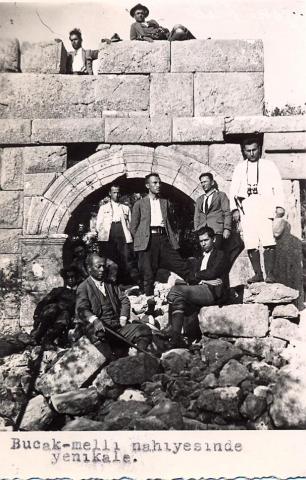 black and white photo of a group of local Turkish men arranged around an arch in a ruined wall