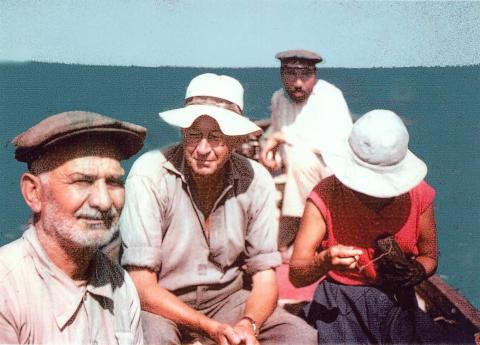 Colour photograph of George and Jane on a boat with two locals