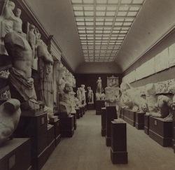 black and white photograph of museum interior with plaster casts