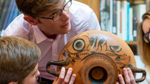 Prof Michael Squire holds up a black figure drinking cup to children