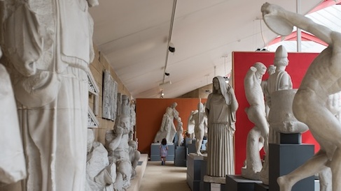 Cast gallery with over-life-size casts and a small family at the far end