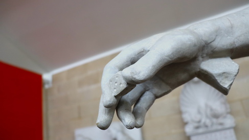 Hand of a statue holding a die.