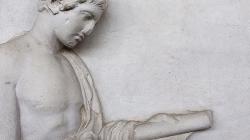 Relief figure of a man looking at a book