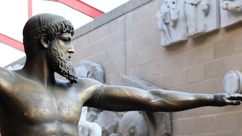 bronze statue with beard and outstretched arm