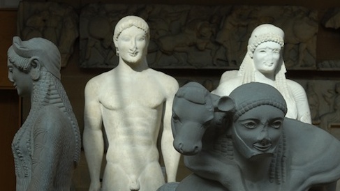 casts in sunlight and shadow: calf carrier in front of statue of naked young man