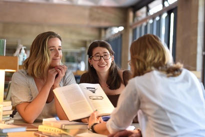 Three postgraduate students in the library 