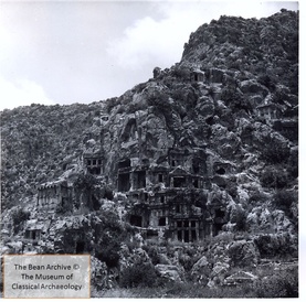 black and white photograph of a hillside with rock-cut tombs