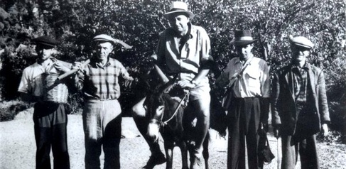 black and white photograph of George on a donkey with four local Turkish guides