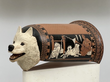 an epinetron, a type of ceramic used to protect the leg while carding wool, decorated with dogs
