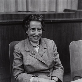 Black and white image of Hannah Arendt, seated and wearing a suit