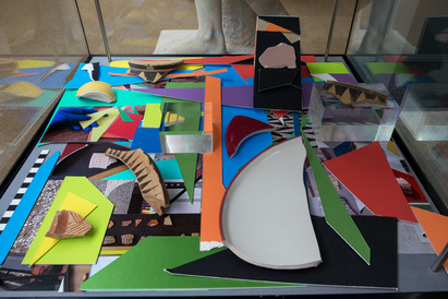 Heavily layered coloured mountboard and photographic images, with ancient sherds and modern broken pottery pieces on top