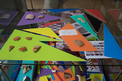 Coloured mountboard shapes with sherds lined up on top, and a handwritten notation