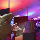 view of the Museum with bright pink and purple lights lighting up the statues
