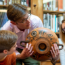 Prof Michael Squire holds up a black figure drinking cup to children