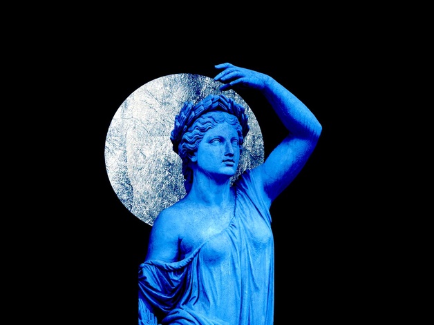 Ancient sculpture in blue holding the silver moon 