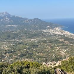 landscape view of island of Samos, with green tree covering central peaks and blue sea in background