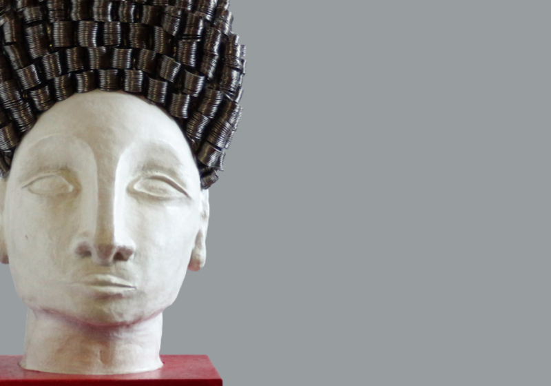 sculpted portrait of woman's face on a red base, with high metallic curls of hair