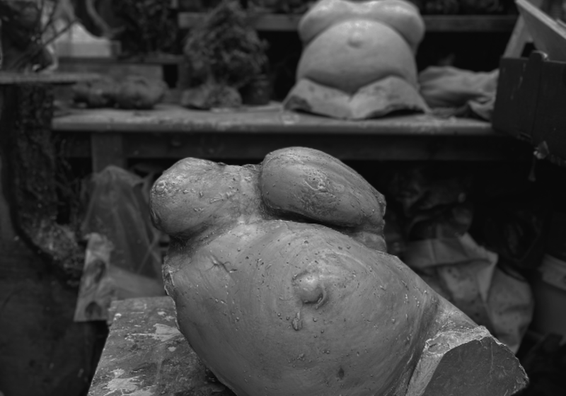 plaster cast of a naked pregnant torso, in an artist's studio