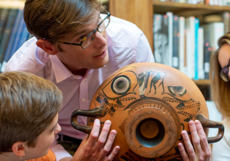 Prof Michael Squire holds up a black figure drinking cup to children