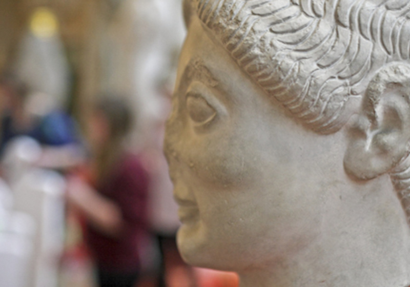 Archaic head with school children out of focus behind