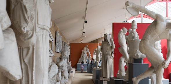 Cast gallery with over-life-size casts and a small family at the far end