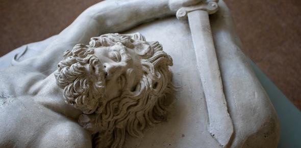 cast of bearded male figure lying down with sword above his head