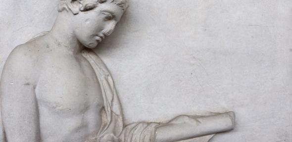 Relief figure of a man looking at a book