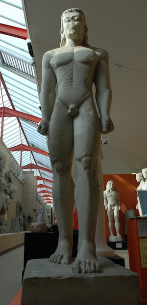 statue of naked young man with hands clenched at sides and one foot in front of other