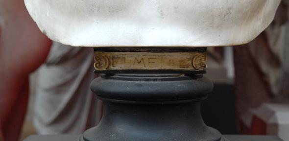 Base of a bust with degraded Greek letters in gold