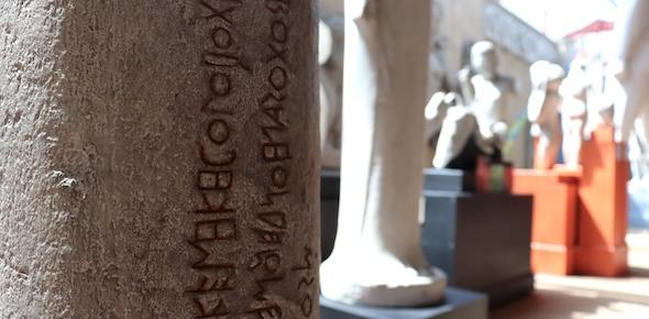 Inscribed text on side of a statue in a museum